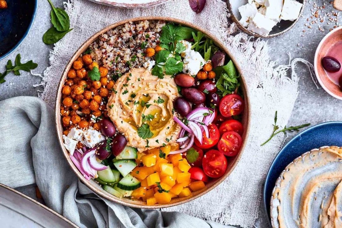 Bowl de comida mediterránea con verduras, hummus y garbanzos